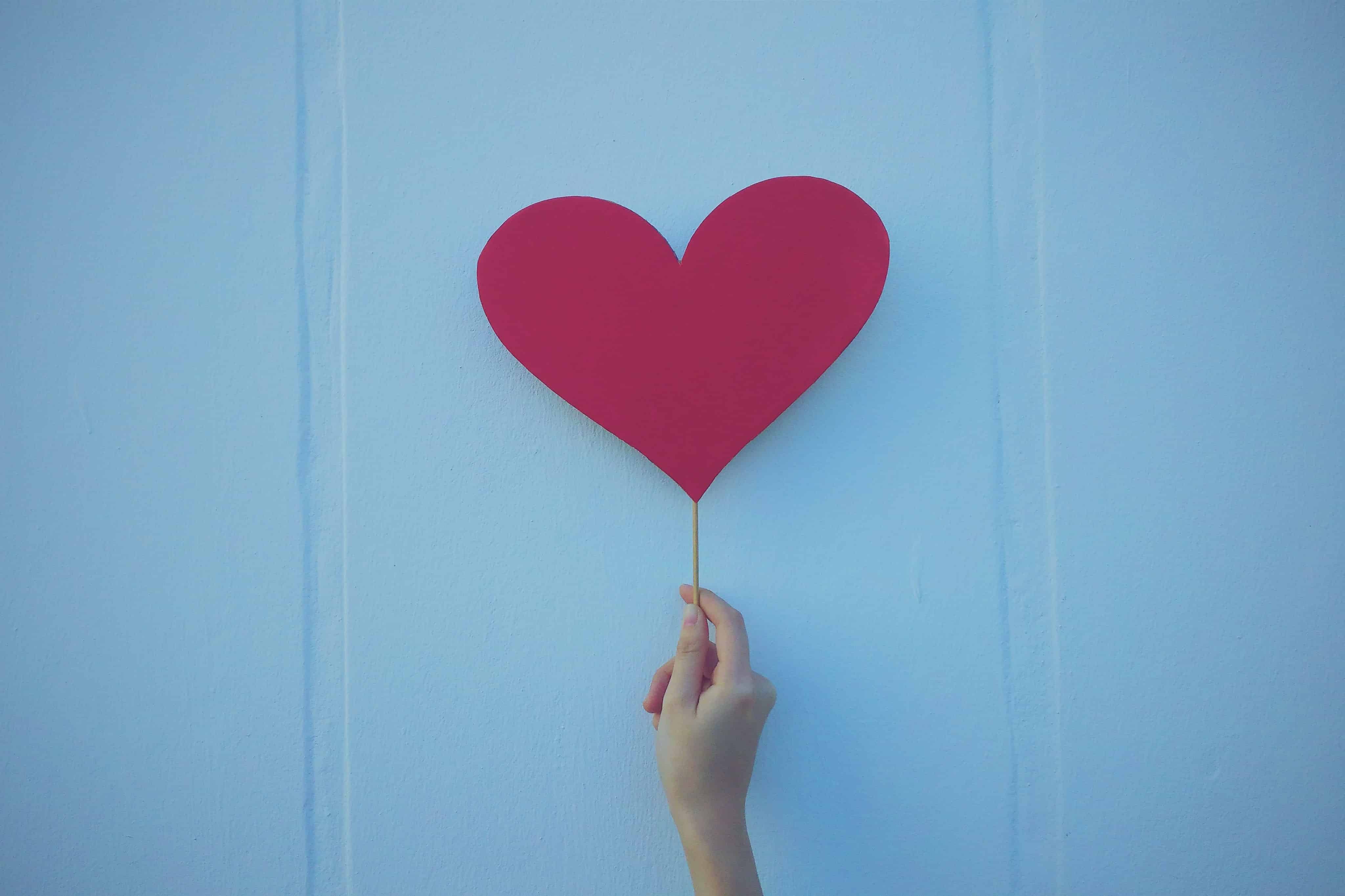 An image of a hand holding a paper heart